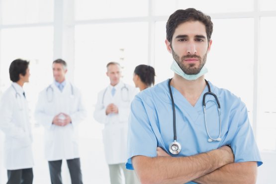 serious-doctor-looking-camera-with-colleagues-him